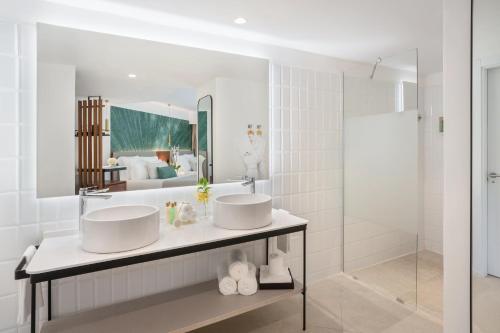 a bathroom with two sinks and a large mirror at Dreams Flora Resort & Spa - All Inclusive in Punta Cana