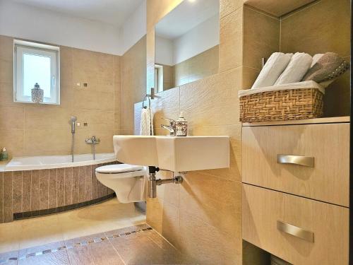a bathroom with a sink and a toilet and a tub at Apartament Garden- parking, ogródek, cicha okolica in Pruszcz Gdański
