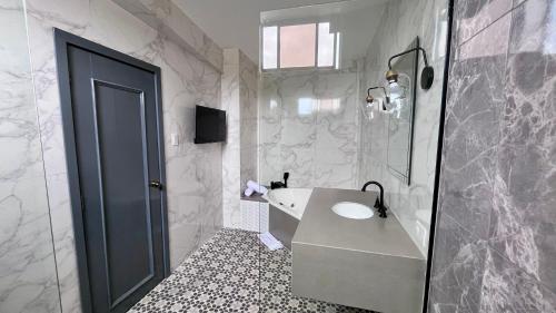 uma casa de banho com um lavatório, uma banheira e um WC. em Hotel Varadero Internacional em Guayaquil