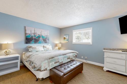 1 dormitorio con paredes azules, 1 cama y ventana en Driftwood en Cannon Beach