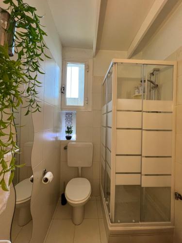 a bathroom with a toilet and a glass shower at Greg's House - enjoy my dolce vita in Grimaldi