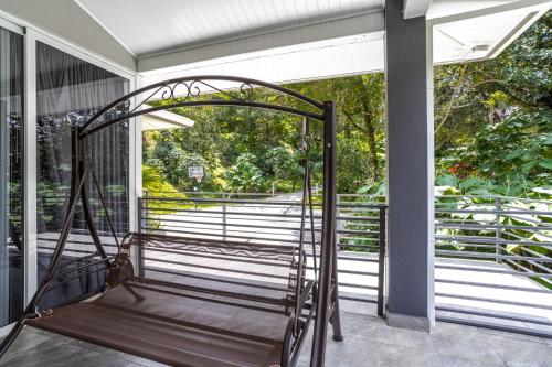 an iron bed on a screened in porch at Coffee Estate Inn in Boquete