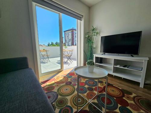 a living room with a couch and a tv and a table at Fascinante Orbita Apartments in Vila Nova de Famalicão