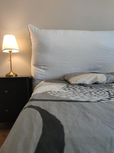 - un lit avec un oreiller et une lampe sur une table dans l'établissement grand appart au calme , proche mer et Stade Vélodrome, à Marseille