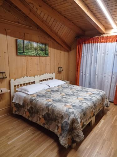 ein Schlafzimmer mit einem Bett in einem Holzhaus in der Unterkunft Locanda Da Pierina in Santo Stefano di Cadore