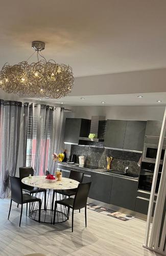une cuisine avec une table et des chaises ainsi qu'un lustre dans l'établissement Gorgeous 2 bedrooms holiday apartement, à Nice
