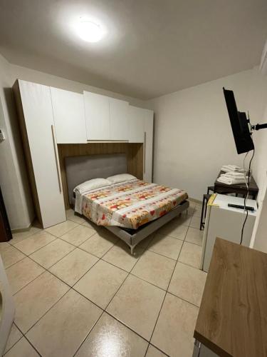 een slaapkamer met een bed, een bureau en een televisie bij Sweet Stabia Dream in Castellammare di Stabia