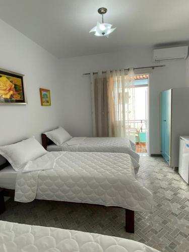 a bedroom with two beds and a window at Vila Nea in Berat