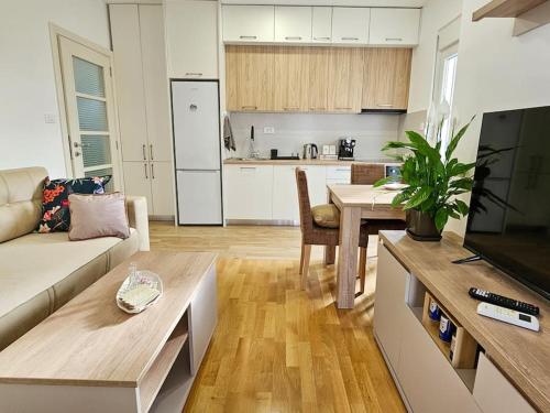 a kitchen and living room with a couch and a table at Blanc in Podgorica