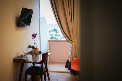 a room with a table and a window with a flower on it at La Risacca Relais in Belvedere Marittimo