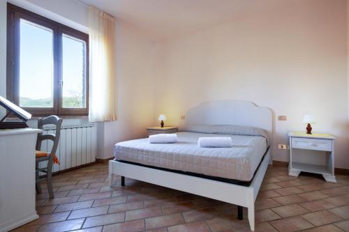 a bedroom with a bed and a desk and a window at Relais Parco Del Subasio in Piano Delle Pieve