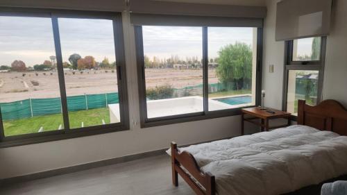 a bedroom with a large window with a view of a pool at Casa En Barrio Privado in Maipú