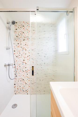 a shower with a glass door in a bathroom at La Cachette du Lac - Parenthèse nature entre piscine, lac & océan in Lacanau