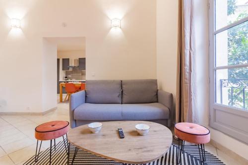 - un salon avec un canapé, une table et des tabourets dans l'établissement Spacieux appartement en plein Coeur de Béziers, à Béziers