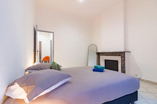 a bedroom with a large bed and a fireplace at Spacieux appartement en plein Coeur de Béziers in Béziers