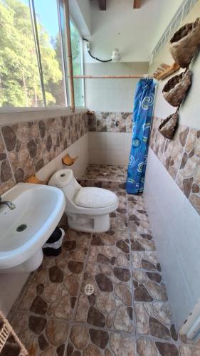 a bathroom with a toilet and a sink at Casa Gaia Paradise in Mompiche