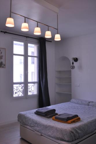 une chambre avec un lit avec deux serviettes dessus dans l'établissement Appt Paris11 Charonne, à Paris