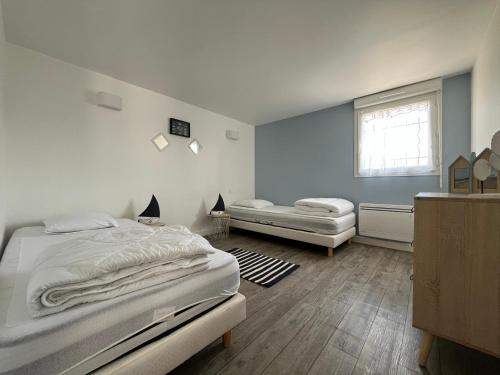 1 dormitorio con 2 camas y ventana en Le Chant des Pierres - En Coeur de Ville en Pornic