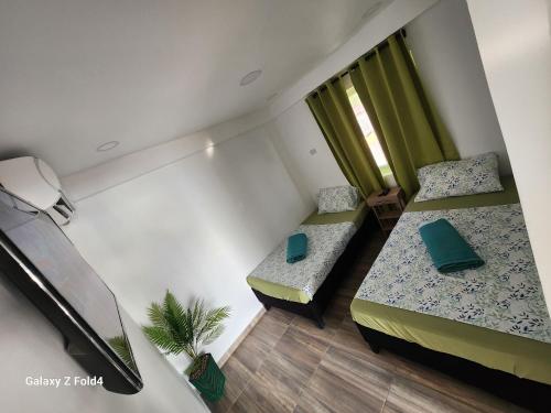 ein kleines Zimmer mit 2 Betten und einem Fenster in der Unterkunft Sea Breeze inn 101 in Providencia