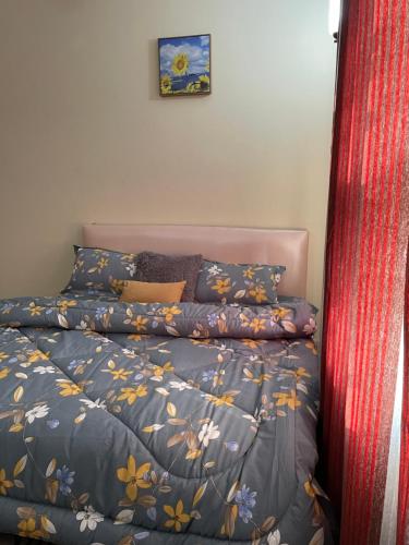 a bedroom with a bed with a blue comforter at Chez nous house in Accra