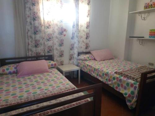 a bedroom with two beds and a window with curtains at شالية مميز للإيجار Porto golf بورتو جولف مارينا in El Alamein