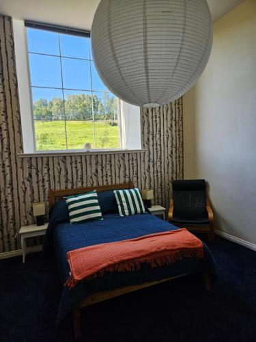 a bedroom with a bed and a large window at Old School, Spean Bridge - fun, friendly, relaxed in Spean Bridge