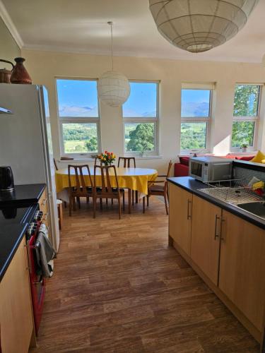 a kitchen with a table and a dining room at Old School, Spean Bridge - fun, friendly, relaxed in Spean Bridge