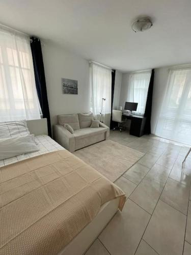 a bedroom with a bed and a couch and a desk at Studio-Apartment mit Balkon in Dresden
