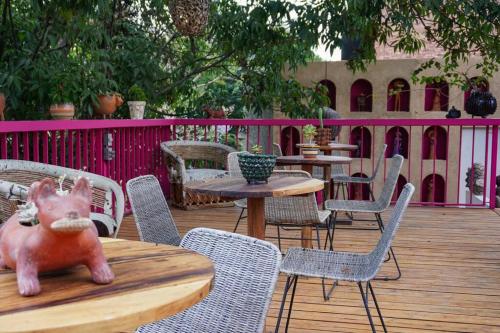 a wooden table with chairs and tables and a pink fence at Casa Nawuales - Terraza - Guadalajara céntrico in Guadalajara