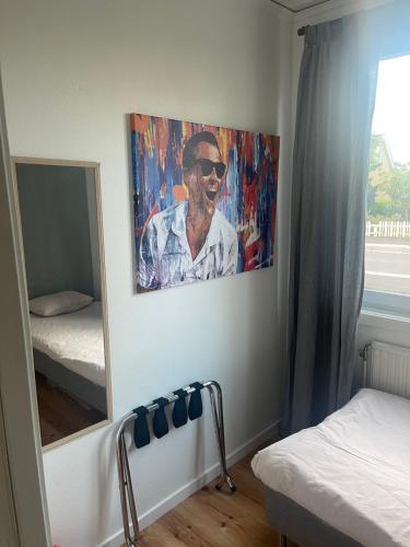 a bedroom with a mirror and a painting of a man at Bergkvara Vandrarhem in Bergkvara
