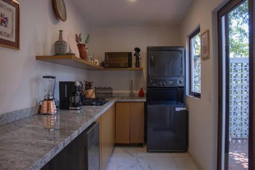 a kitchen with a refrigerator and a tv on a counter at Casa Nawuales - Terraza - Guadalajara céntrico in Guadalajara