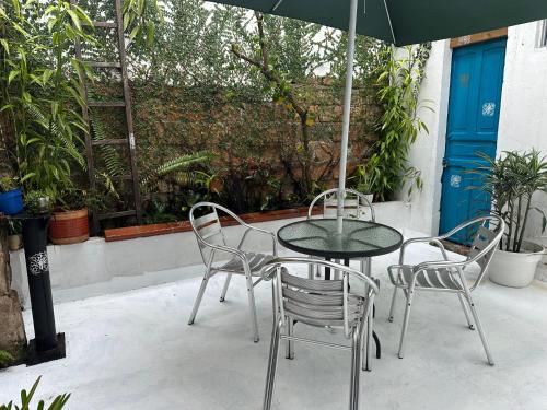 a table and chairs with an umbrella on a patio at Hotel Casa Lucca in Medellín