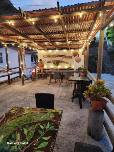 un patio con pérgola de madera, mesa y sillas en Sea Breeze inn 102, en Providencia