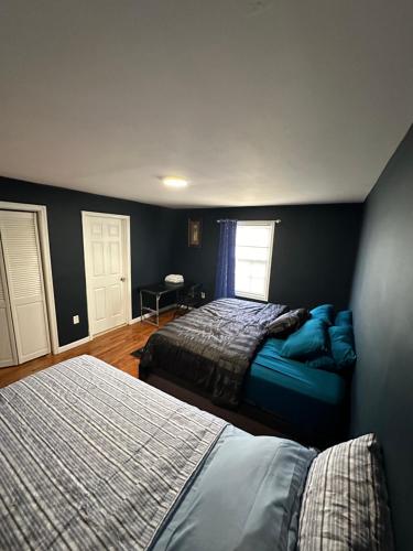 a bedroom with two beds and a window at Fidelia Amethyst Room, King Bed and Twin Bed with Private Bathroom Minutes From Newark Liberty International Airport and Newark Penn Station in Irvington