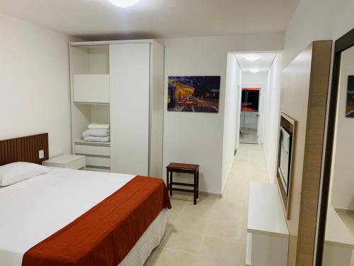 a bedroom with a bed and a walk in closet at Lagamar Hotel Varginha in Varginha