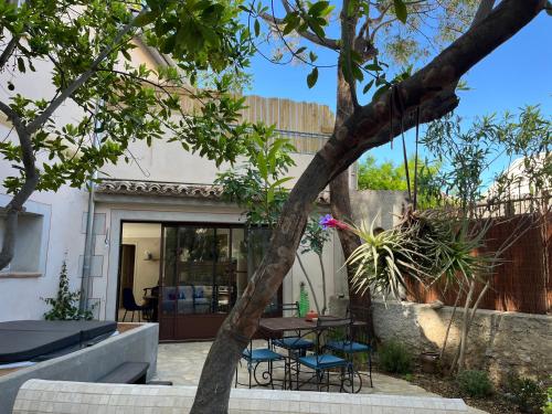 a house with a courtyard with a table and chairs at La Maison de Auguste in Coursan