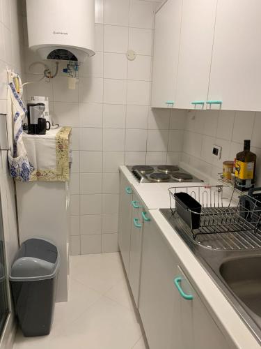 uma cozinha branca com um lavatório e um fogão em Relax Au Soleil em Menton