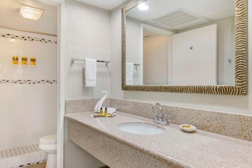 a bathroom with a sink and a mirror and a toilet at Best Western Plus Palm Desert Resort in Palm Desert