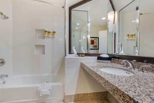 ein Badezimmer mit einem Waschbecken, einer Badewanne und einer Dusche in der Unterkunft Best Western Plus Palm Desert Resort in Palm Desert