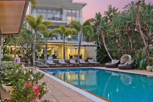 a hotel with a swimming pool in front of a building at Wave Culture 1204 Beach Bliss - Apartment with complex Pool & Spa in Kingscliff