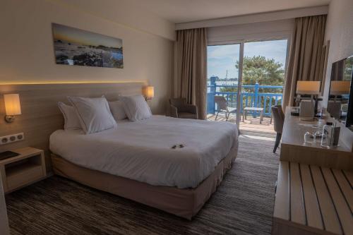 a hotel room with a bed and a balcony at Best Western Plus Le Roof Vannes Bord de Mer in Vannes