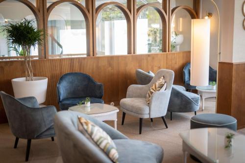 a waiting room with chairs and tables and windows at Best Western Plus Le Roof Vannes Bord de Mer in Vannes