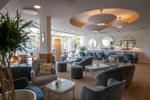 a lobby with couches and tables and mirrors at Best Western Plus Le Roof Vannes Bord de Mer in Vannes