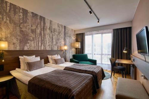 ein Hotelzimmer mit 2 Betten und einem TV in der Unterkunft Scandic Swania in Trollhättan