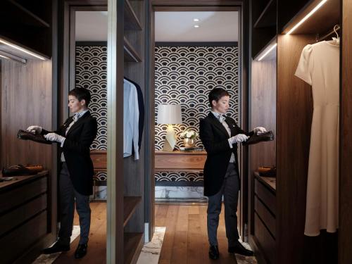 two men in suits standing in a dressing room at Anantara Palazzo Naiadi Rome Hotel - A Leading Hotel of the World in Rome