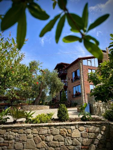 a building with a stone wall in front of it at Bujtina Ajazi in Golem