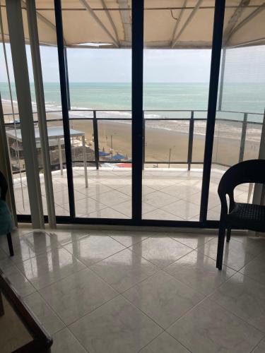 a room with a view of the beach from a building at Departamento 4 habitaciones 12 personas vista al mar 8vo piso Playa Almendro in Tonsupa