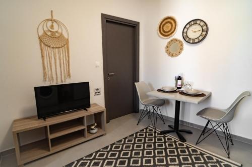 a living room with a tv and a table with chairs at Maquestas Modern Apartments in Archangelos