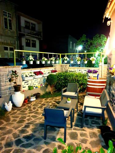 a group of chairs and tables on a patio at night at Gago Apartments in Struga