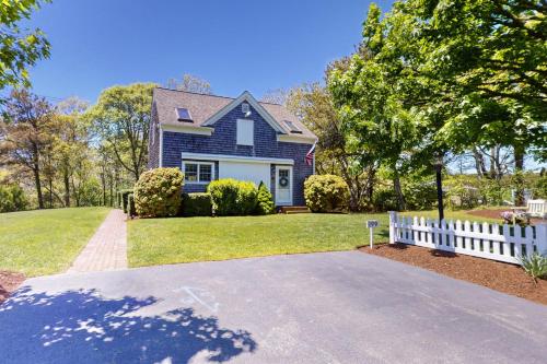 a blue house with a white fence in the yard at Dreamcatcher in Chatham